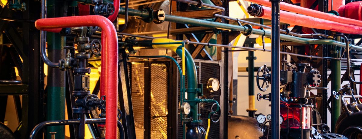 Complex network of industrial pipes and machinery inside a Lisbon plant.